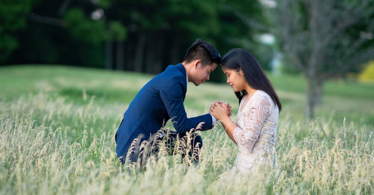 A romantic scene of a couple in a meadow sharing an intimate moment.