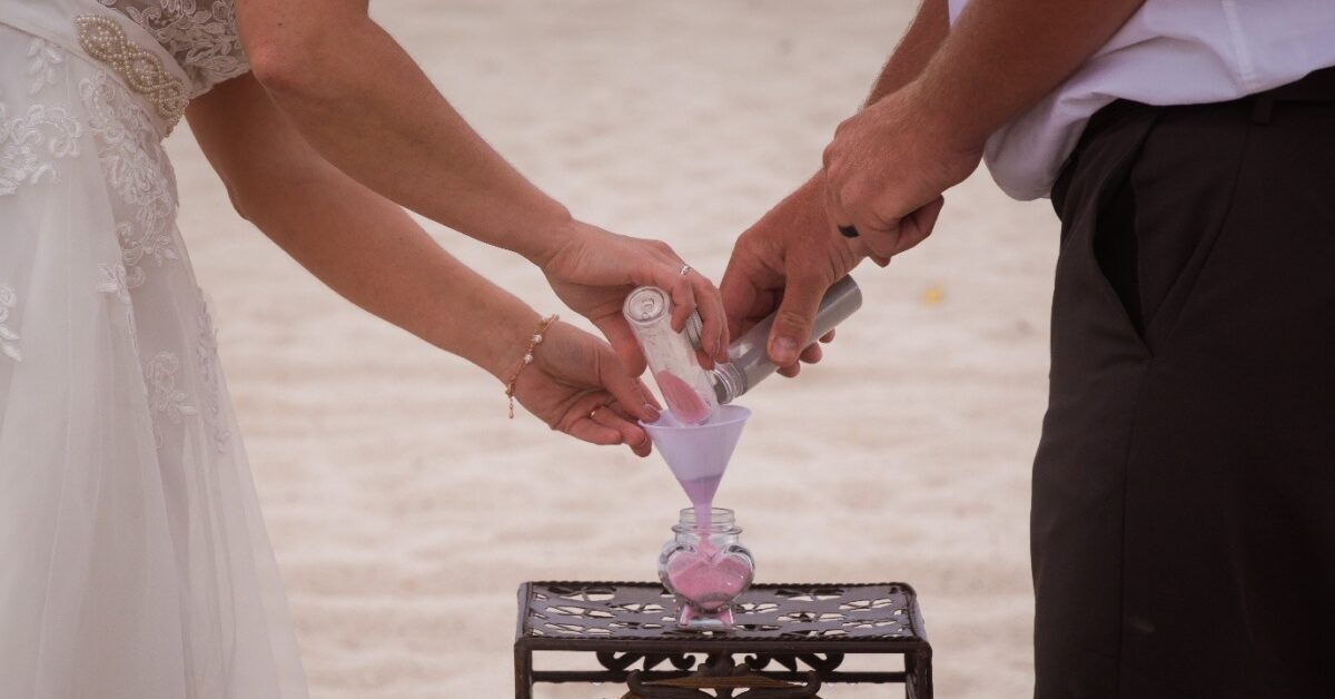 A bride and groom stand together with a pink wedding cake, celebrating their marriage and vows with a celebrant in Melbourne.