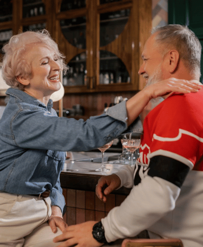 An older couple enjoying drinks together at a bar, celebrating their commitment and love for each other.